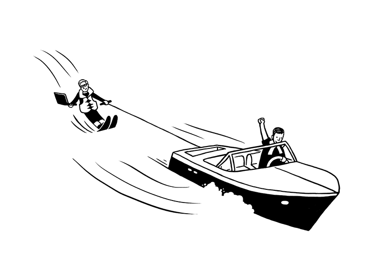 Person in a suit and tie water skiing while holding a laptop, being pulled by a motorboat driven by another person.