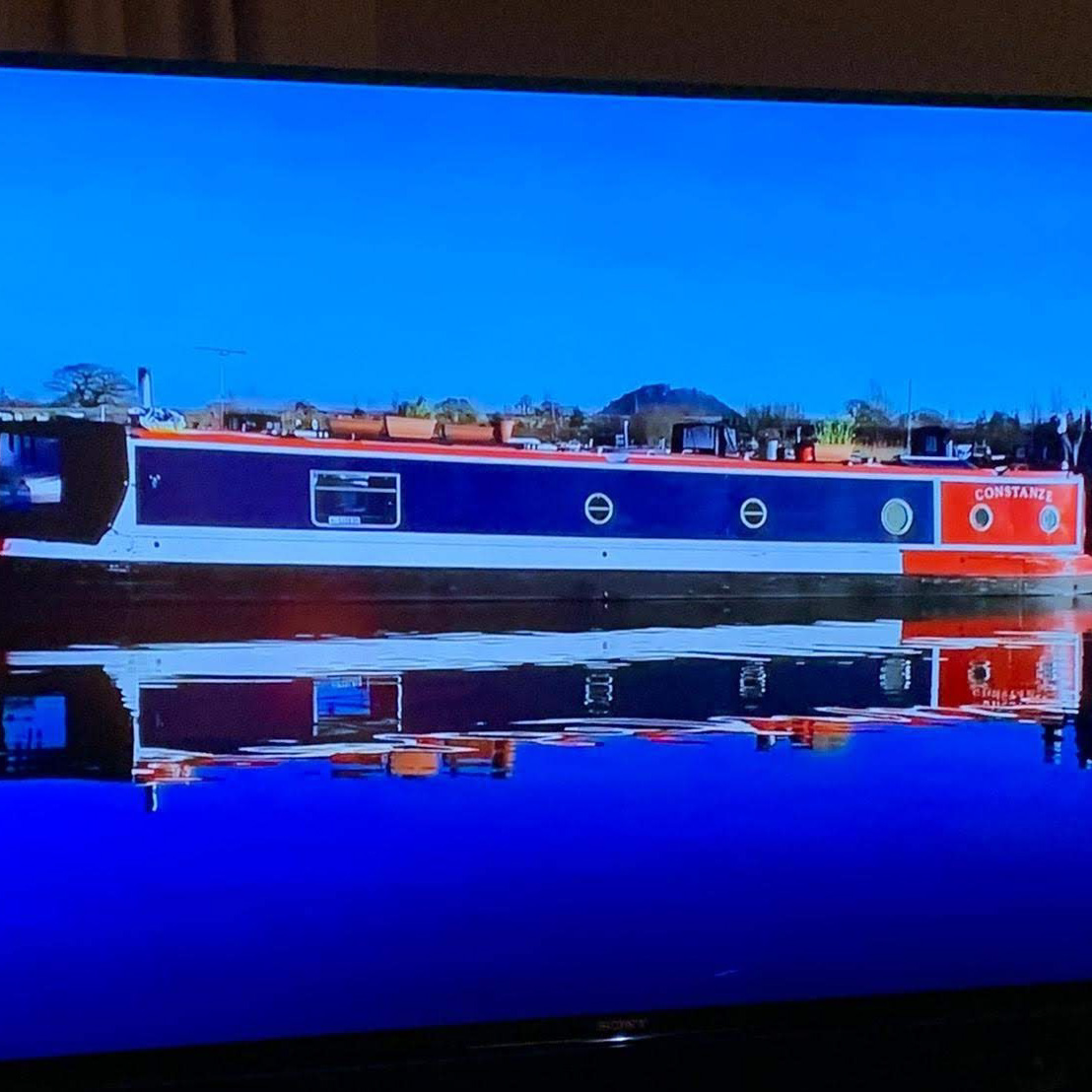 A blue and red canal boat named 